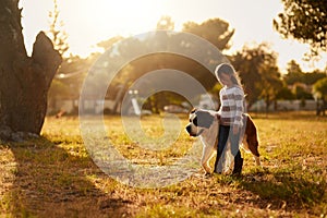 Hes her four-legged shadow. a cute little girl walking through a park with her dog.