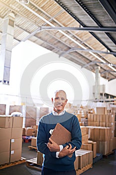 Hes a logistics professional. Portrait of a mature man standing on the floor of a warehouse.