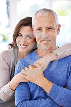 Hes my man. a handsome older man and his younger wife enjoying time at at home.