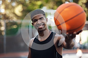 Hes one aspiring athlete. Portrait of a sporty young man standing on a basketball court.
