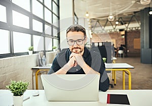 Hes onto something innovative. a mature businessman working on his laptop in the office.