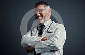 Hes positive about your prognosis. Studio shot of a handsome mature male doctor looking thoughtful while standing with