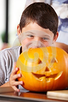 Hes ready for a candle. A happy young boy showing off his Jack Olantern to the camera.