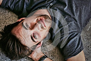 Hes a real mans man. High angle portrait of a beaten and bruised young man lying down on the floor.