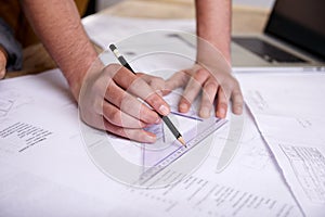 Hes a skilled draftsman. a draftsman drawing up building plans using a triangle.