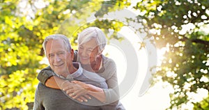 Hes still her knight in shining armour. an affectionate senior man piggybacking his wife at the park.