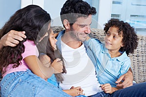 Hes such a devoted father. a happy single parent family sitting on a sofa and smiling at each other.