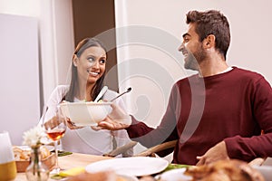 Hes such a gentlemen. A happy couple enjoying a family meal around the table.