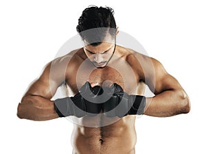 Hes in it to win it. Studio shot of a fit young man wearing boxing gloves against a white background.