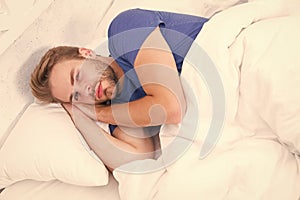 Hes too lazy to get up. Lazy man lying in bed. Handsome man after waking up in lazy morning. Being a little lazy