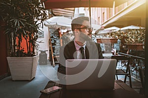 Hesitating man employer with laptop waiting in street restaurant