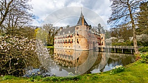 Het Oude Loo castle with its bridge, surrounded by its moat with reflection in the water and trees