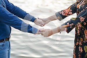 Heterosexual Caucasian couple holding hands playfully against a blurred background