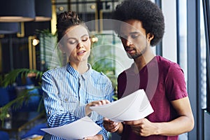 Heterosexual couple analyzing important documents in the office