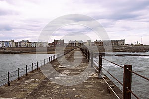 Heugh breakwater pier looking back at houses in small town