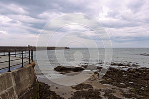 Heugh breakwater pier from shore in stormy, cloudy weather seascape