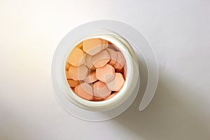 Hexagon shape tablets in white plastic jar in medical healthcare drugstore concept,closed up