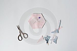 Hexagon template, scraps, quilting pin and scissors