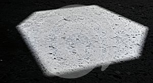Hexagonal light patch on concrete in black and white