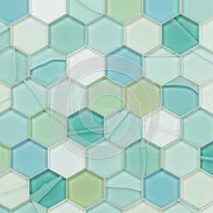 Hexagonal mosaic tiles in shades of green and blue create a geometric pattern