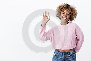 Hey give me high five. Friendly, joyful charismatic girlfriend with blond afro haircut in winter stylish sweater raising