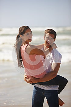 Hey, no peeking. Shot of a young couple being playful on the beach.