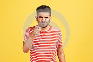 Hey you! Angry bossy man with beard in striped t-shirt grimacing pointing finger at camera, scolding and blaming you