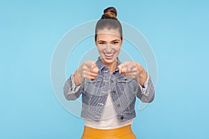 Hey, you are awesome! Portrait of joyful happy fashionably dressed woman with hair bun pointing fingers to camera