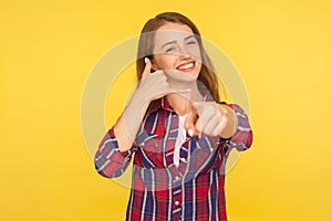 Hey you, call me back! Portrait of sweet lovely beautiful girl in shirt doing telephone gesture near ear and smiling, waiting for