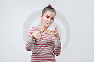 Sassy woman pointing with finger at camera blaming you in all troubles.