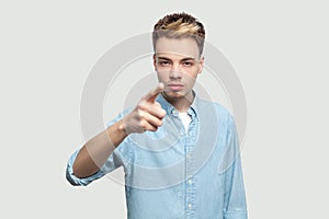 Hey you. Portrait of serious bossy handsome young man in light blue shirt standing, accusing and looking at camera with serious