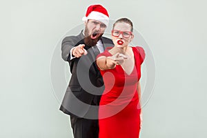Hey you. Seriously businessman and woman looking at camera, pointing fingers and alert.