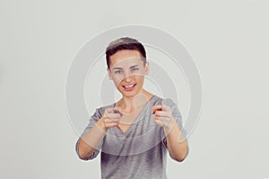 Hey you! Woman pointing at camera, point index finger gesture isolated on light grey background. Human emotions, facial
