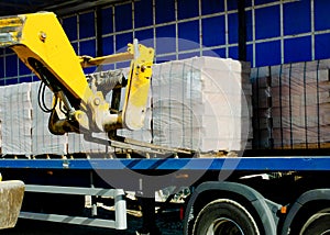 HGV delivered concrete blocks on construction site and telehandler offloading it photo