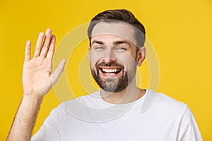 Hi, Hello. Portrait of happy friendly brown-haired man with small beard in white shirt waving hand to camera, welcoming