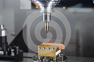 The   hi-precision CNC milling machine cutting the copper electrode material and G-code data background.