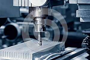 The Hi-precision CNC milling machine with cutting sample in blue-silver tone.The micro cutting technique in precision part