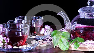 Hibiscus Red tea mug with carnation flowers close-up horizontal photo.English tea tradition.Medicinal therapy based on medicinal