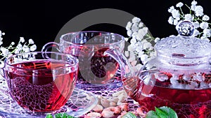 Hibiscus Red tea mug with carnation flowers close-up horizontal photo.English tea tradition.Medicinal therapy based on medicinal