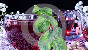 Hibiscus red tea mug with tea leaf or mint leaf close-up horizontal photo.Medicinal therapy on medicinal herbs and decoctions.