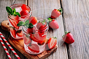 Hibiscus strawberry rhubarb iced tea with mint. Ice cold summer cocktail or lemonade in mason jar