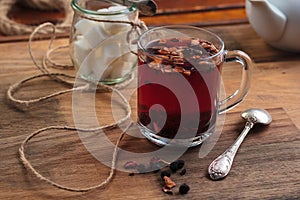 Hibiscus tea with fruit pieces and sugar in glass