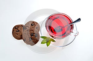 Hibiscus tea glass cup on a saucer with mint leaves, spoon and c