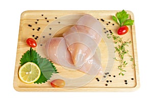 Hicken breast fillet and spices on wooden cutting board photo