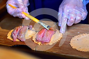 Hida beef sushi on rice cracker being prepared in Japan