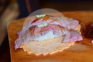 Hida beef sushi on rice cracker being prepared in Japan