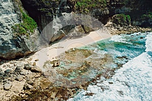 Hidden beach with rocks and ocean with waves in Bali. Aerial view