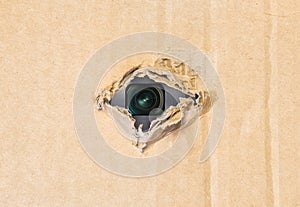 Hidden camera in torn hole in cardboard paper