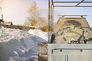 Hidden cargo in plastic bags in the trailer of a passenger car, on a broken country road in the spring, the foreground and