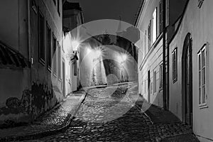 Hidden fairytale street in Prague Czech Republic Novy Svet quarter enlightened by street lamps during night black and white